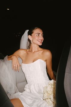 a bride sitting in the back seat of a car