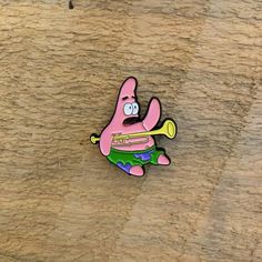 a pink cartoon character holding a tennis racquet on top of a wooden surface