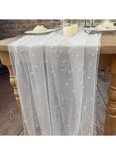 the table is covered with white sheer fabric