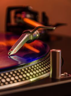 a turntable that is sitting on top of a table with a pen sticking out of it