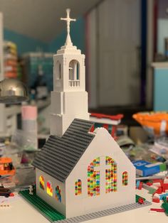 a lego model of a church with a white steeple and stained glass windows on top