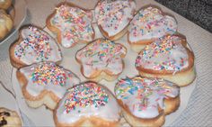 a white plate topped with donuts covered in frosting and sprinkles