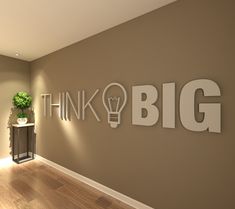 there is a sign that says think big next to a plant in a vase on the wall