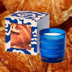 a blue candle sitting next to a box of croissants