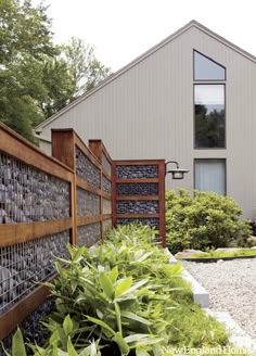 a garden with rocks and plants in front of a house