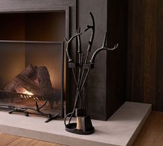 a fireplace with some branches on the mantle next to it and a pair of scissors