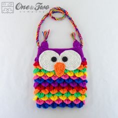 a crocheted owl purse hanging from a string on a white background with the words one and two written across it