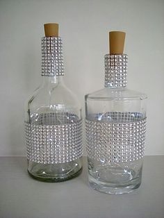 two crystal bottles with cork tops on a table