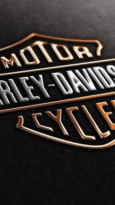 the harley davidson logo is shown in gold and silver on a black background with white lettering