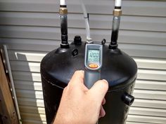 a person is checking the temperature on a water heater