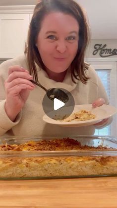 a woman holding a plate with food on it and spoon in front of her face