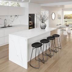 a white kitchen with marble counter tops and stools in front of the bar area