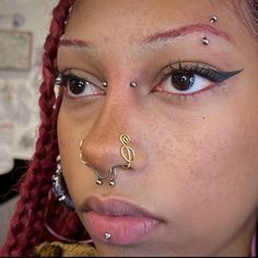 a close up of a person with piercings on their nose and nose ring in front of her face