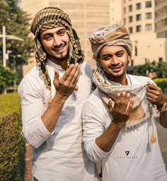 two men standing next to each other holding something