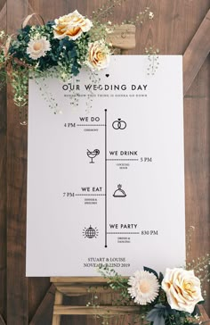 a wedding program with flowers and greenery on the side of a wooden table next to a sign