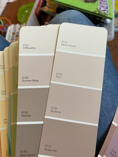 three pans of paint sitting next to each other in front of a person's legs