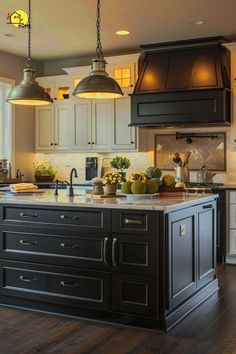 a large kitchen with an island and two pendant lights hanging from the ceiling above it