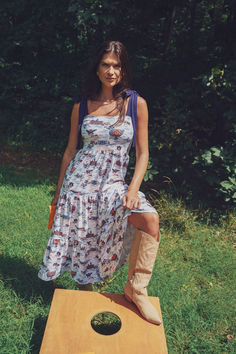 a woman standing on top of a wooden board in the grass with her legs crossed