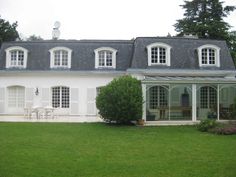 a large white house sitting on top of a lush green field