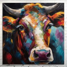 a painting of a cow on a white brick wall with blue eyes and yellow horns