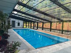 an indoor swimming pool surrounded by greenery