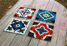 four different colored tiles sitting on top of a wooden table