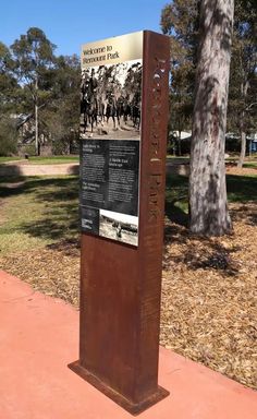 a sign in front of a tree that says, the museum is located at the end of