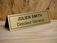 a sign that says julien smith director general on it's gold plated plaque