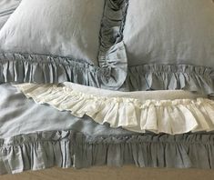 an unmade bed with ruffled sheets and pillows