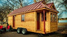 a tiny wooden house with a red roof