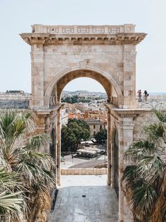 an archway leading into the city with palm trees