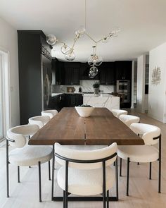 a large wooden table surrounded by white chairs