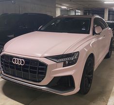 an audi car is parked in a parking garage with other cars behind it on the concrete