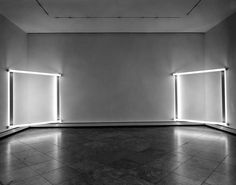 an empty room with three lights on either side of the wall and one light at the end