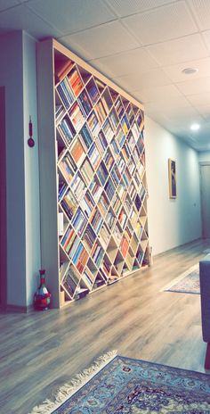 a living room filled with furniture and a large book shelf on the wall behind it