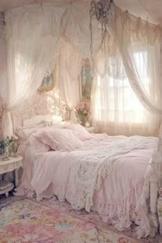 a white bed sitting next to a window covered in curtains and pink bedspread