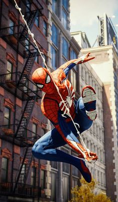 a spider man statue hanging from the side of a building