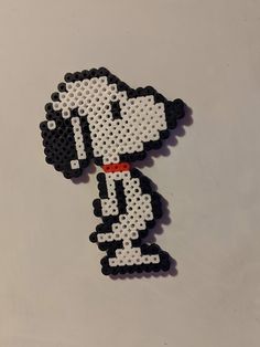 a black and white dog with red collar on it's head is made out of perler beads