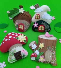 some little houses made out of felt on a green surface