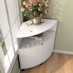 a vase filled with flowers sitting on top of a white cabinet next to a window