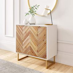 a white and wood cabinet with a round mirror on the wall next to it in a room