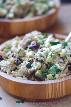 two wooden bowls filled with food on top of a table