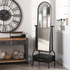 a large mirror sitting on top of a wooden floor next to a shelf with drawers