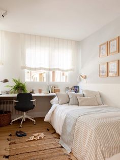 a bedroom with a bed, desk and chair in it next to a window that has vertical blinds