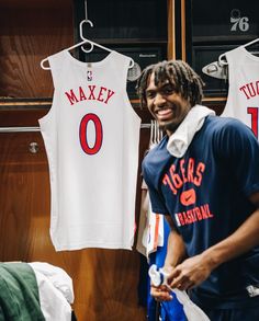 a man standing in front of two basketball jerseys