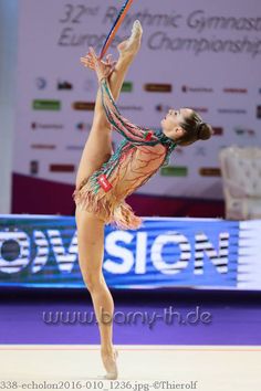 a woman is performing on the floor with a tennis racquet in her hand