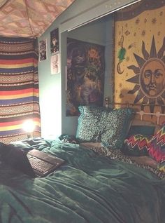 a bed with pillows and blankets on top of it in a room filled with pictures