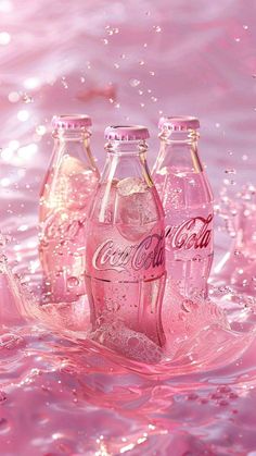 three pink coca - cola bottles are in the water