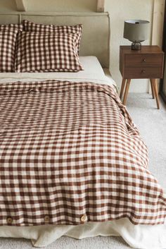 a brown and white checkered comforter on a bed in a room with two nightstands