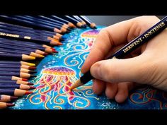 someone is drawing with colored pencils in their hand